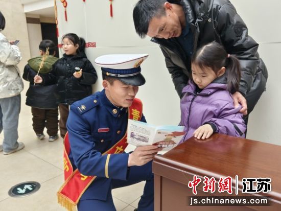 消防员向小朋友讲解宣传册。沛县消防供图